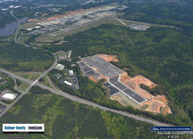 Aerial view of a large construction project near Raleigh-Durham International Airport surrounded by dense greenery.